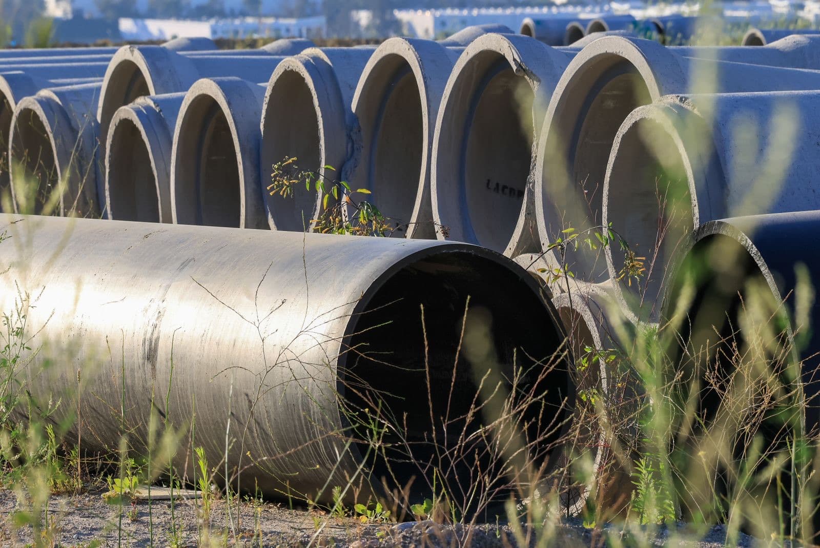 stock photograph of concrete drainage pipes stacked on site. Licensed stock picture, not a photograph of Tami Plumbing, its staff, its premises or a job it carried out.
