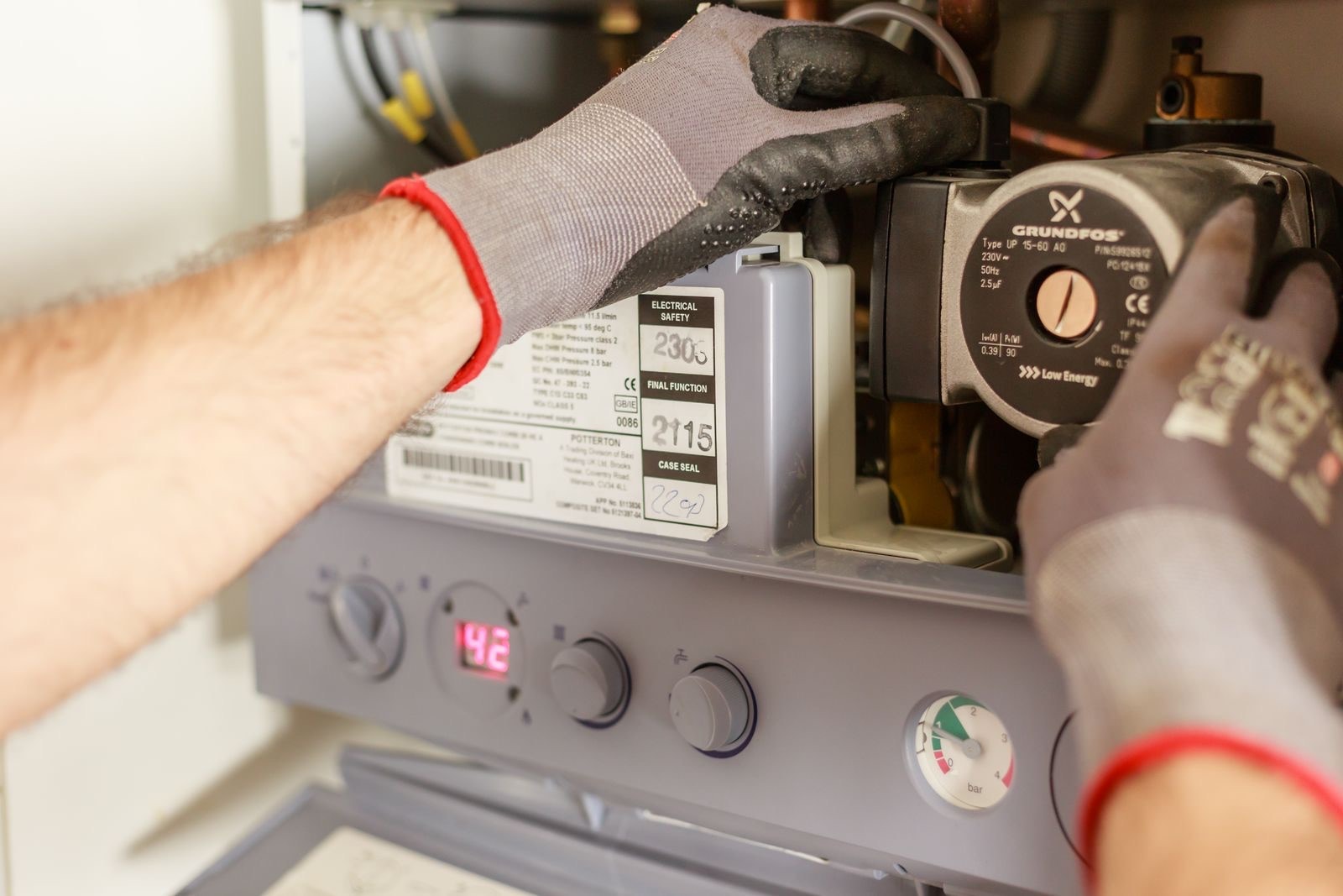 stock photograph of a central heating boiler circulating pump being serviced. Licensed stock picture, not a photograph of Tami Plumbing, its staff, its premises or a job it carried out.