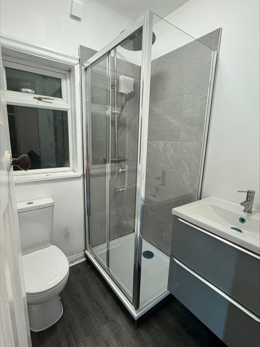 Complete bathroom refit with walk-in shower, vanity unit, and new flooring - after